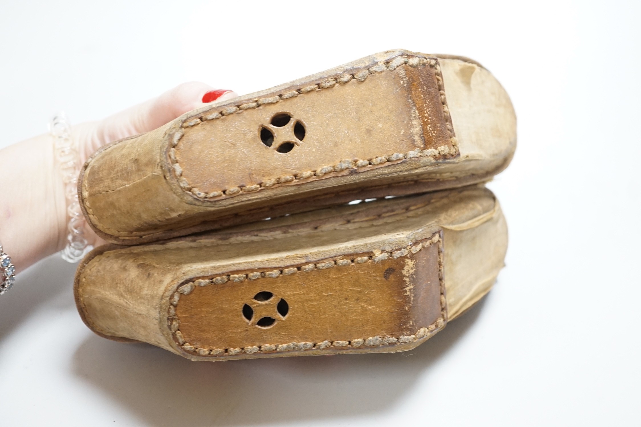 A pair of late 19th century Chinese silk embroidered shoes with Bell inset soles